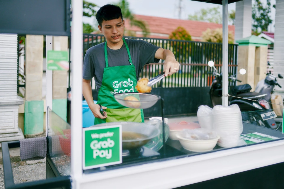 a man in an apron cooking food on a grill